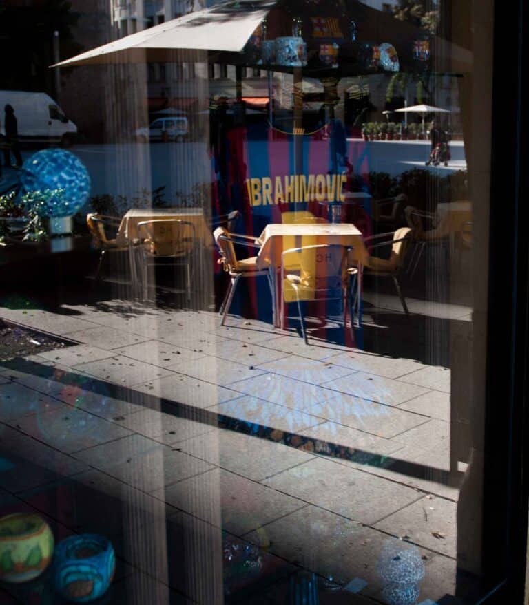 An image showing the superimposed reflection of the street while also showing the inside of the store.