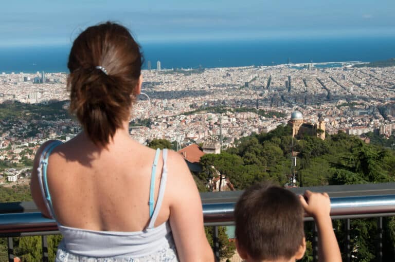 A family looking at the view of the city from Tibidabo.