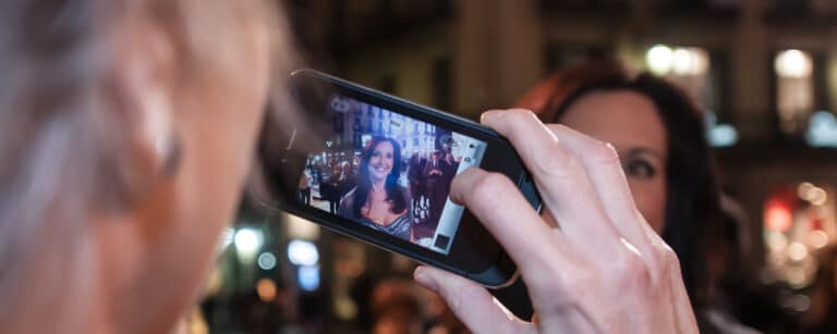 A person holding their phone and reviewing their just taken photo.