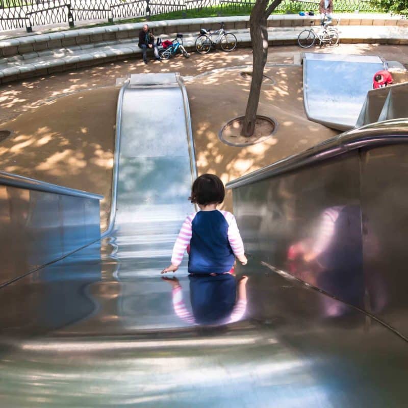 A little girl on the large slide at Diagonal mar park.