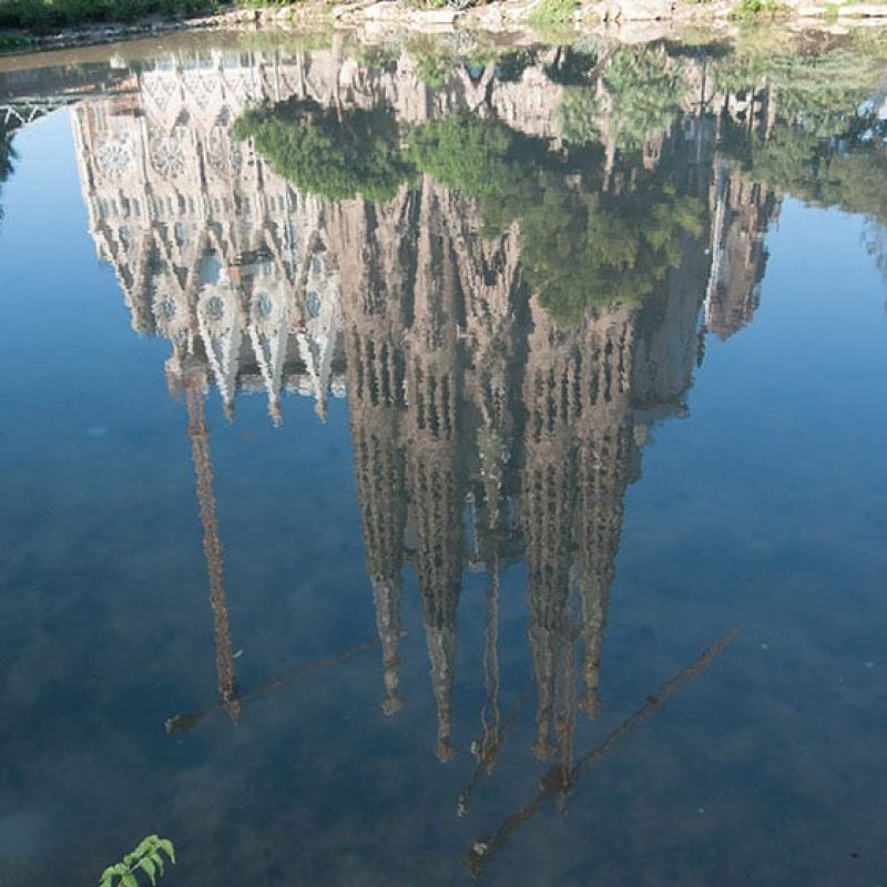 The Sagrada Familia reflected in the water.