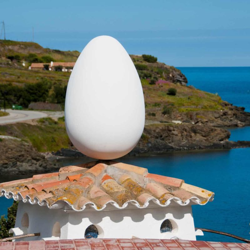 An egg sits atop his chicken coup.