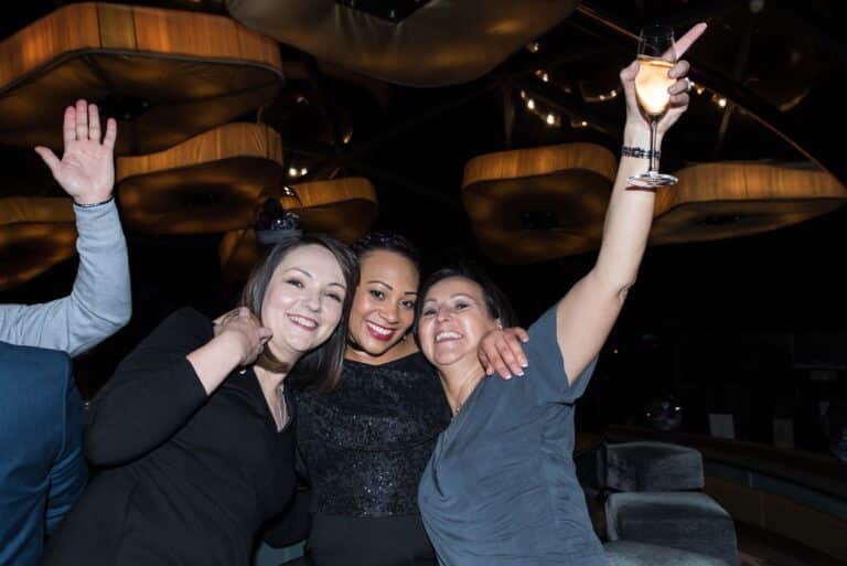 Three friends having fun at their gala diner party.