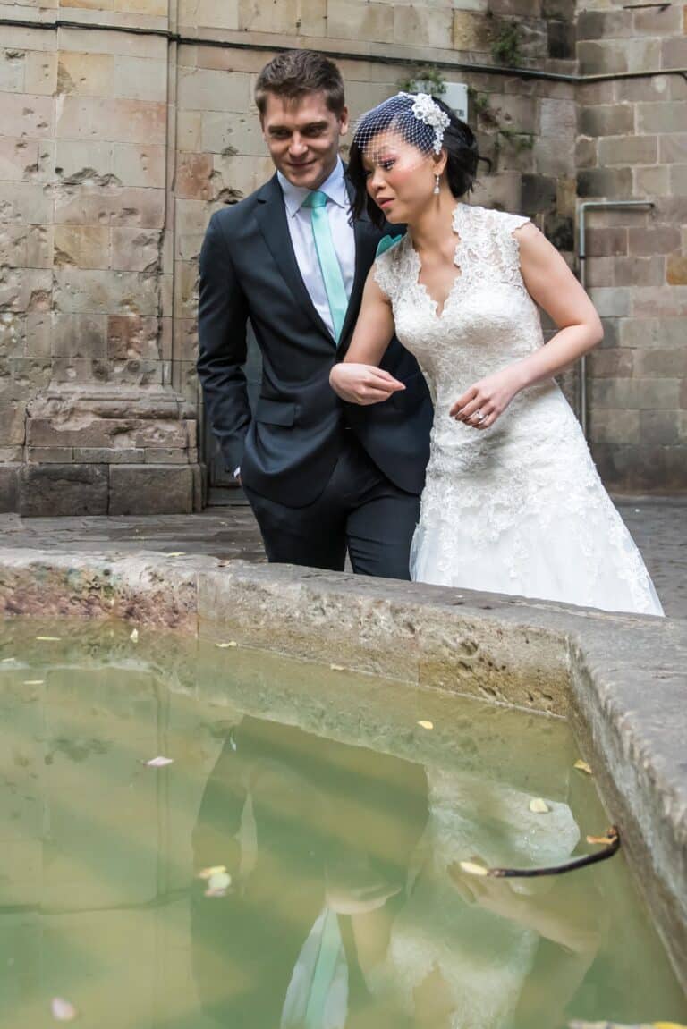 A couple in front of a fountain in the gothic quarter during a photo session.