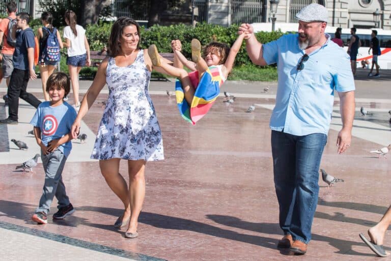 A family of 4 enjoying a moment together in a Barcelona Plaza.