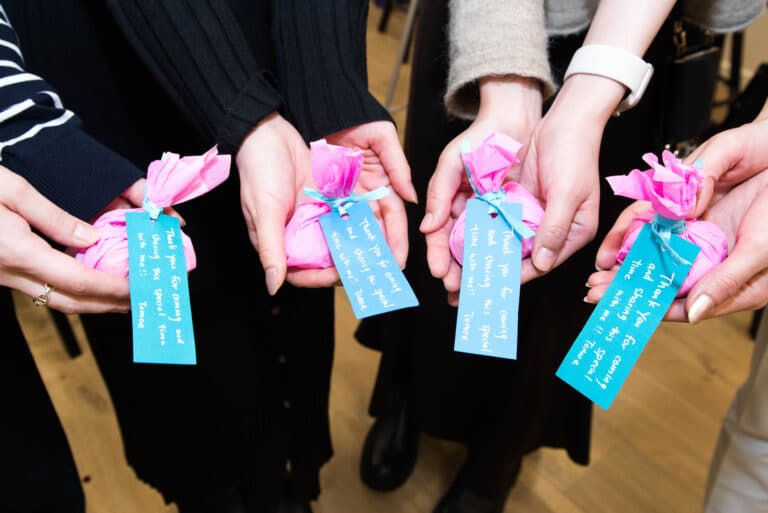 A small thank you gift held in their hands at this baby shower.
