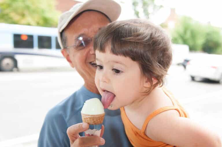 Grandfather and granddaughter enjoying a summer ice cream cone.