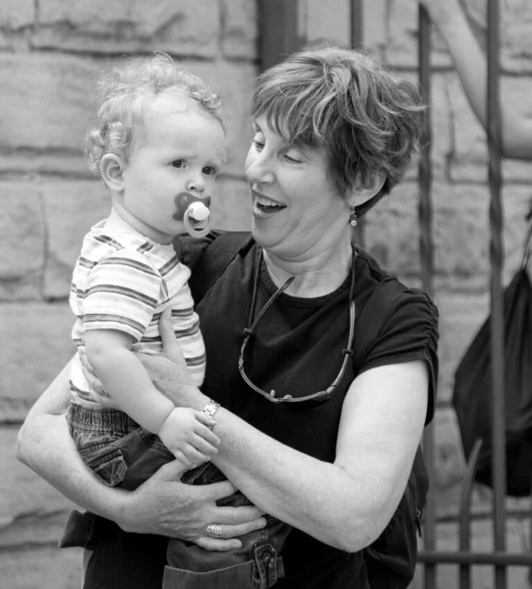 Grandma with her grandson in a medieval plaza in Barcelona during their family photo session.